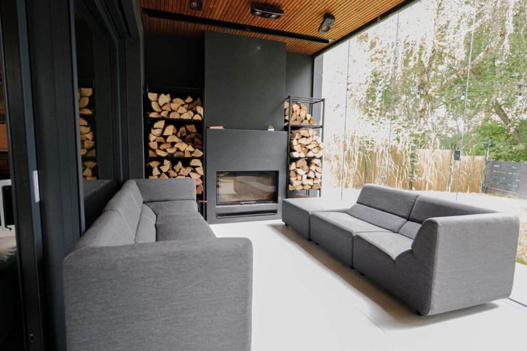 Salon w stylu japandi – naturalne drewno, kominek i panoramiczne przeszklenia