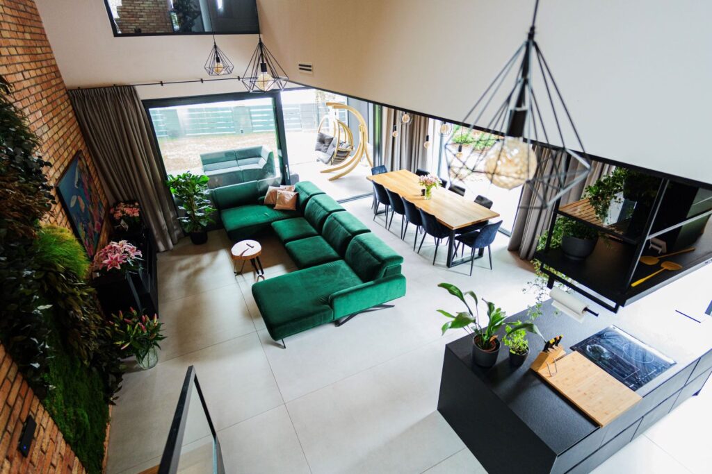 Widok z góry na nowoczesną strefę dzienną z dużymi przeszkleniami i funkcjami inteligentnego domu