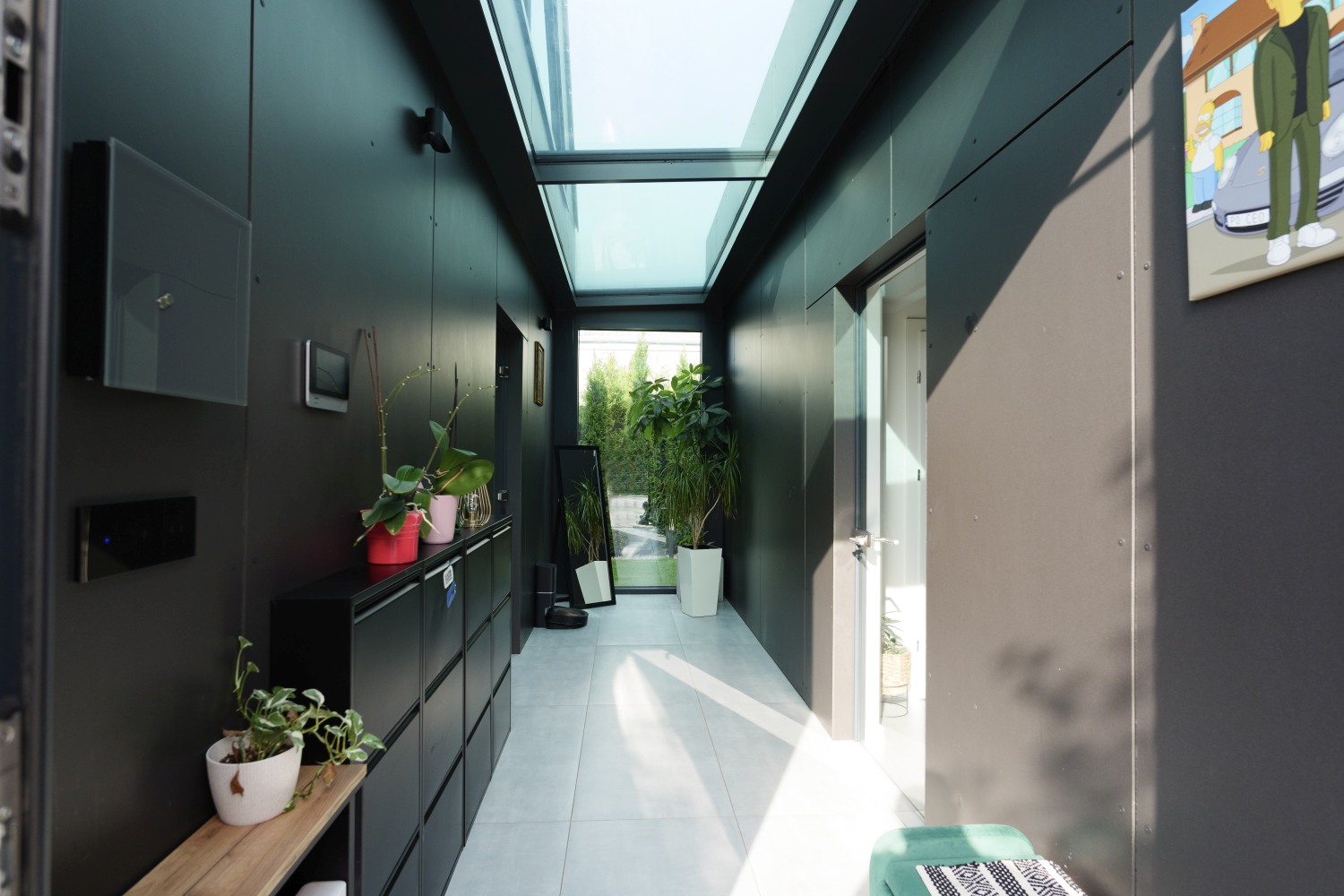 Przeszklona strefa komunikacyjna domu jednorodzinnego prowadząca do części prywatnej