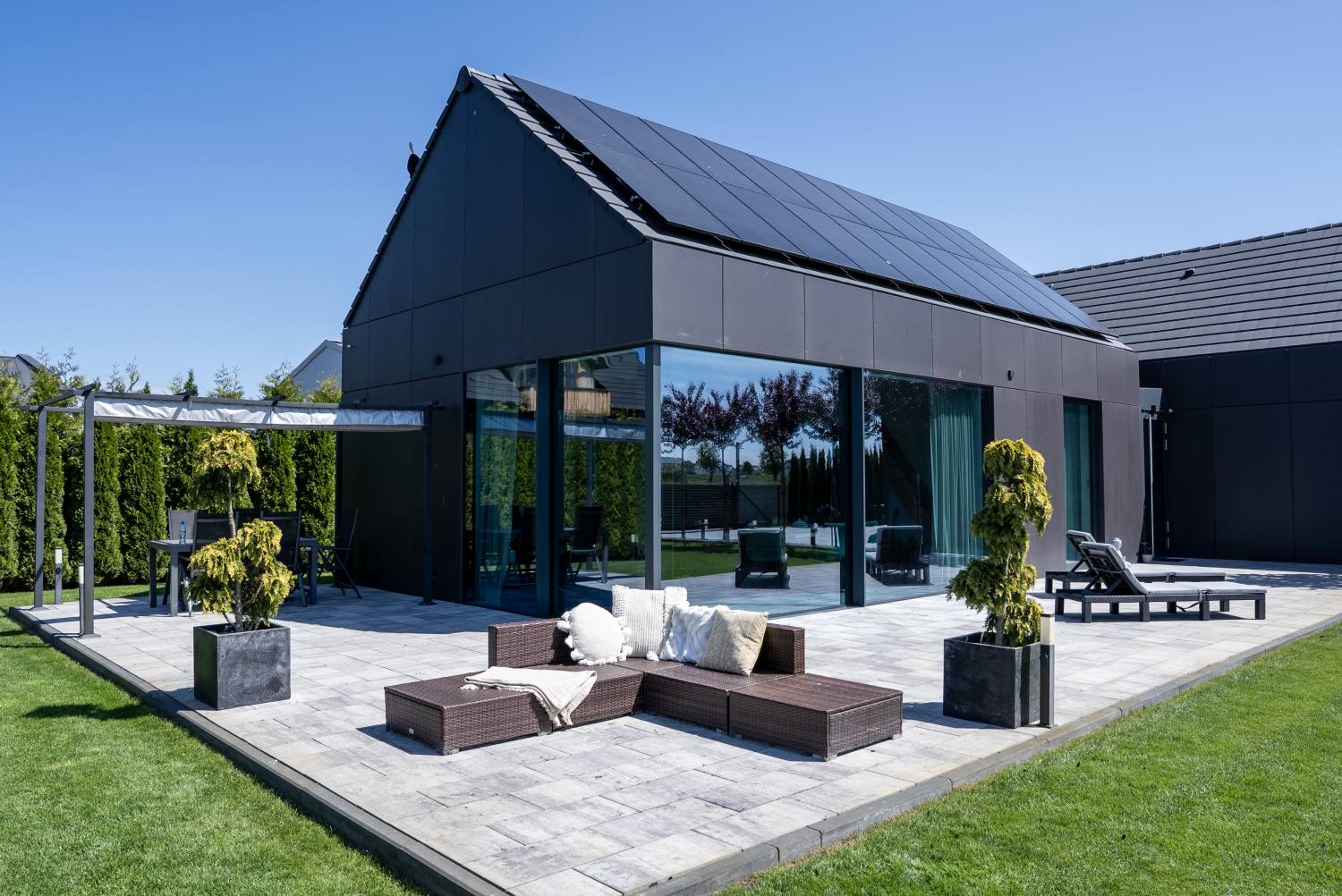 Nowoczesny dom z dachem skośnym i panelami fotowoltaicznymi na elewacji