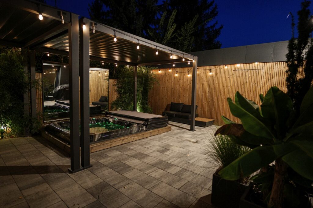 Pergola z oświetleniem jako zadaszenie tarasu całorocznego w nowoczesnym ogrodzie