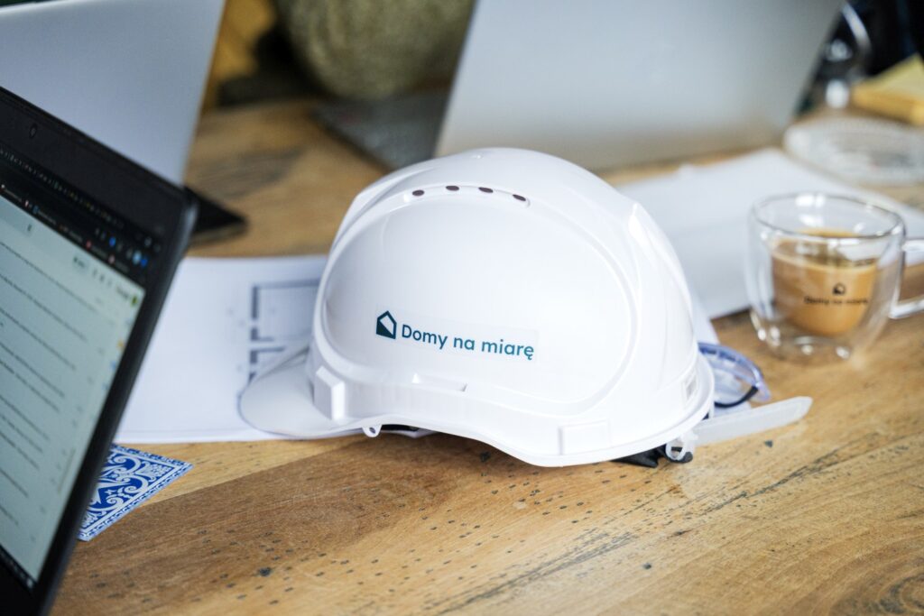 Kask Domy na Miarę leżący na dokumentacji projektowej – przykład profesjonalnego przygotowania inwestycji