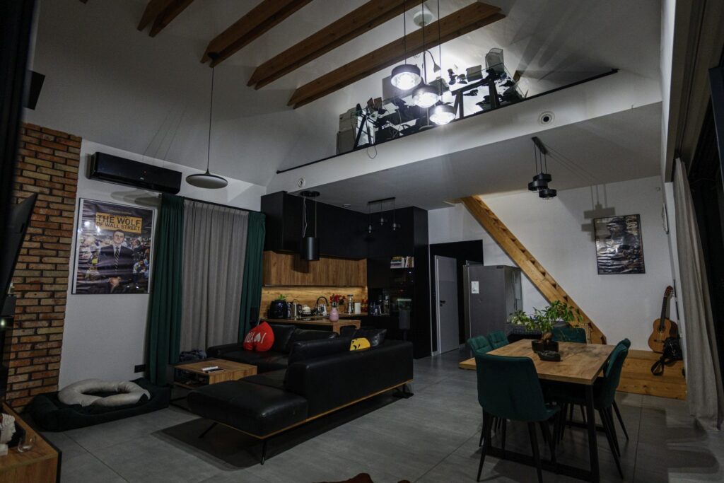 Salon z kuchnią w domu premium, wysoki sufit i drewniane belki