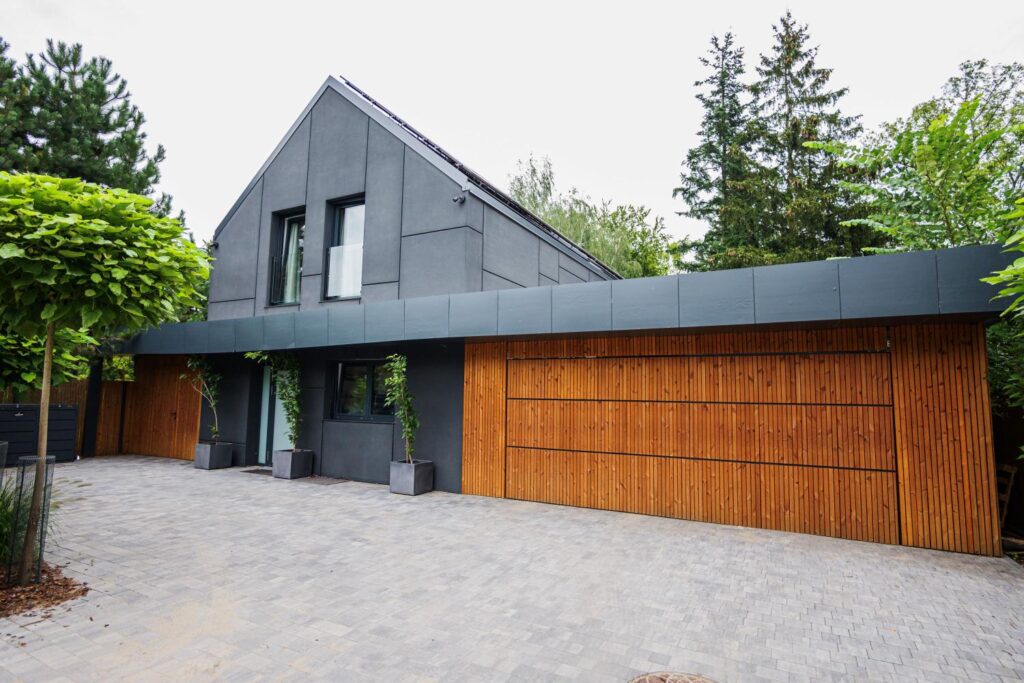 Elewacja nowoczesnego domu z drewnianymi akcentami, idealna do montażu kamer i czujników systemu alarmowego